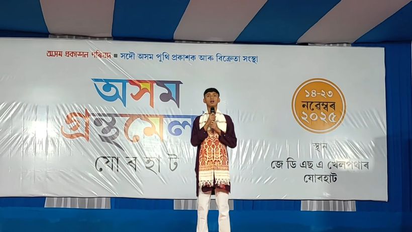 A student in a gamosa speaking at the microphone