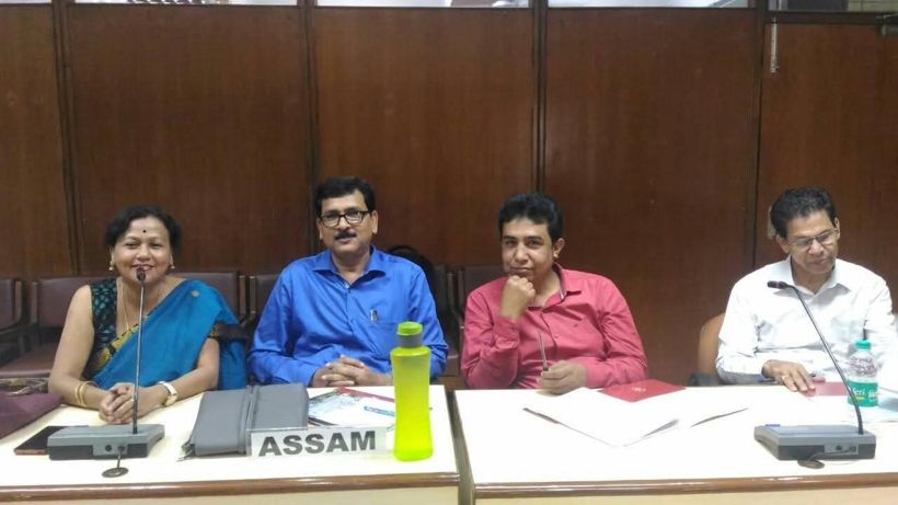 Shyamalima Borah and three colleagues seated at a conference table behind an Assam name card