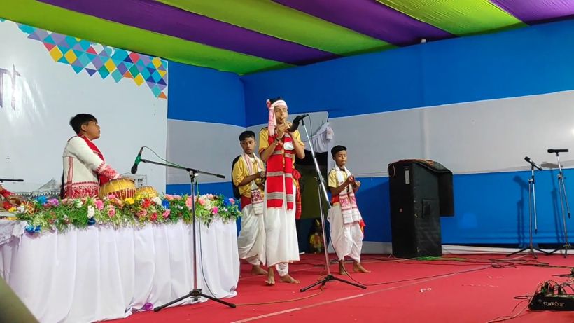 Students in dhoti and gamosa singing