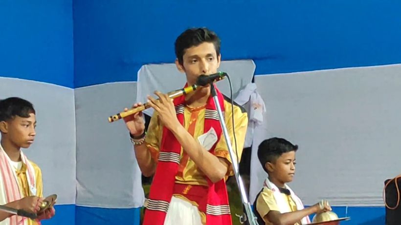 A student playing the flute beside young musicians