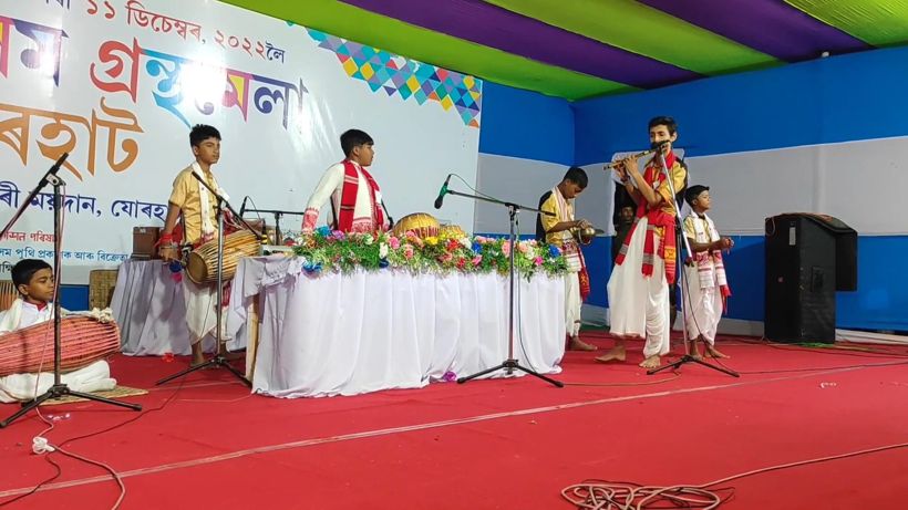 Musicians on a stage with a flower-laden table